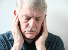 Older man in pain holding his ears